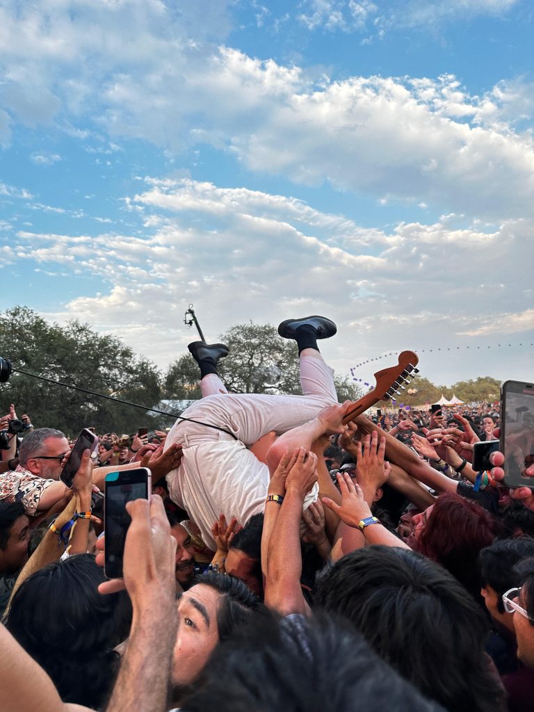 Lee Kiernan, de IDLES, navegando sobre la multitud en un electrizante crowdsurfing mientras suena "Never Fight a Man With a Perm". Captura de Mayté Oliva para El Timbre Suena.
